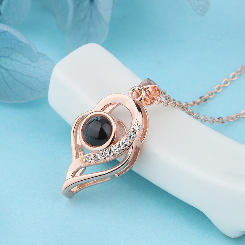 Real compact projection necklace showing a multilingual love message